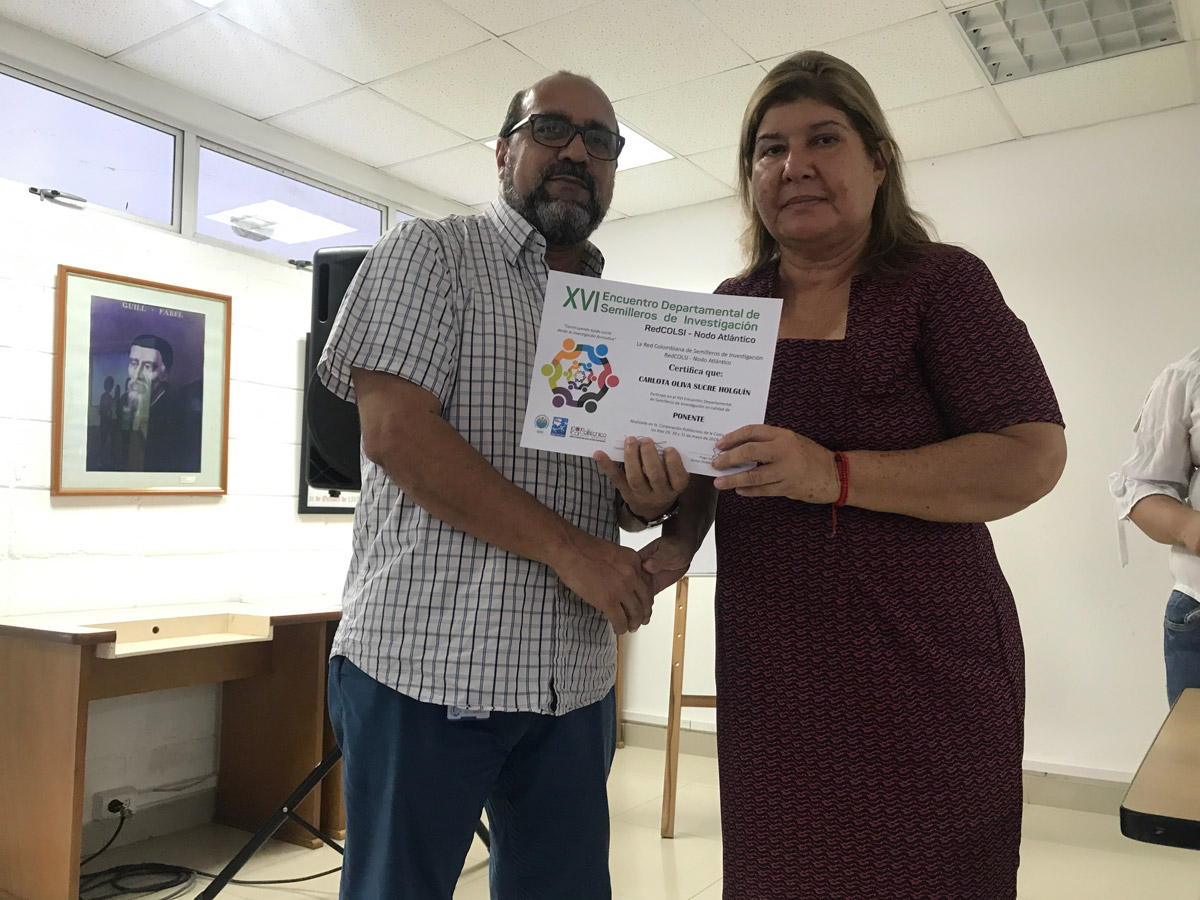 Carlota Olivia Sucre Holguín (Semillero REMEFES, Teología) recibiendo reconocimiento del Vicerrector Milcíades Púa.