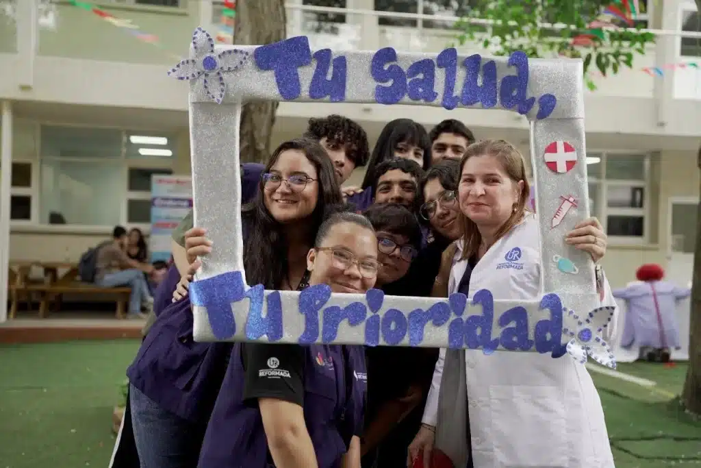 Del 14 al 17 de octubre de 2025, la Corporación Universitaria Reformada llevó a cabo la Semana de la Salud Integral, una iniciativa promovida por el área de Bienestar estudiantil, con el propósito de fomentar el autocuidado, la salud preventiva y el bienestar físico y emocional de toda la comunidad universitaria. Durante los cuatro días de programación, estudiantes, docentes y colaboradores participaron en diversas actividades de promoción de la salud, entre ellas jornadas de vacunación, valoración odontológica, escáner corporal biocuántico, diagnóstico de piel con inteligencia artificial, campañas de prevención del cáncer de mama y salud intestinal, así como espacios dedicados al bienestar mental, como el stand “Escanea tu estado emocional”. La jornada también incluyó espacios de relajación y autocuidado, como los masajes terapéuticos de manos y cuello, además de muestras de emprendimiento en productos de belleza y bienestar, lideradas por estudiantes de los programas de salud. Estas actividades permitieron que la comunidad universitaria reflexionara sobre la importancia de cuidar la mente y el cuerpo, promoviendo hábitos saludables que contribuyen al desarrollo integral. La Semana de la Salud Integral también se destacó por la interdisciplinariedad y el compromiso estudiantil, evidenciado en la participación docentes y aliados estratégicos que acompañaron las jornadas. Cada actividad se convirtió en un espacio de aprendizaje experiencial, donde el conocimiento académico se conectó con la vida cotidiana y las necesidades reales de la comunidad. Además, la iniciativa fortaleció la cultura institucional del bienestar, impulsando la integración entre facultades y el sentido de pertenencia hacia la UniReformada. La participación masiva y el entusiasmo de los asistentes reflejaron el impacto positivo de estas acciones que, más allá de promover la salud, fomentan una vida universitaria más plena, humana y solidaria. Con esta iniciativa, UniReformada reafirma su compromiso con la salud, la vida y el bienestar, consolidando su visión de formar profesionales y ciudadanos conscientes, saludables y comprometidos con la construcción de una sociedad más humana y solidaria.